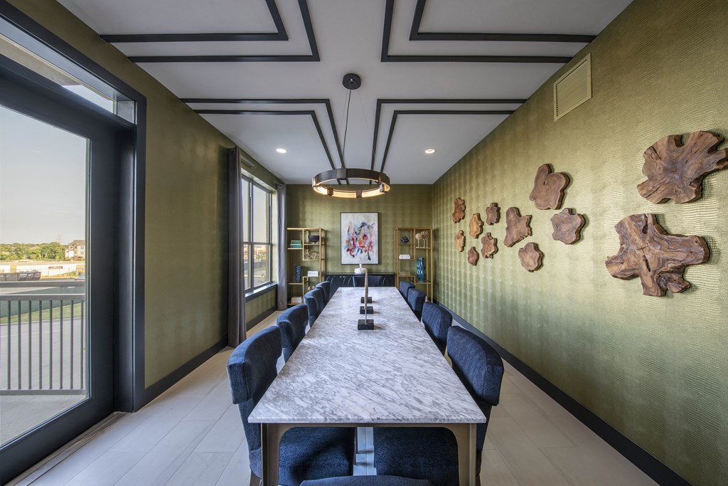 a long table with chairs and a painting on the wall