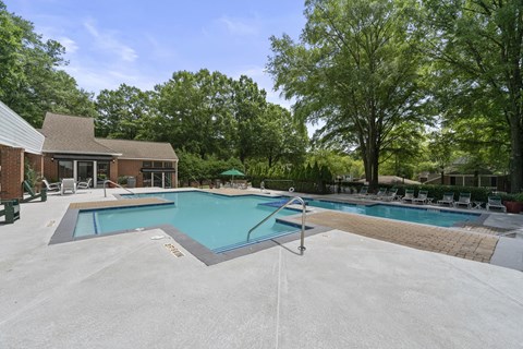 A swimming pool surrounded by trees and a building.