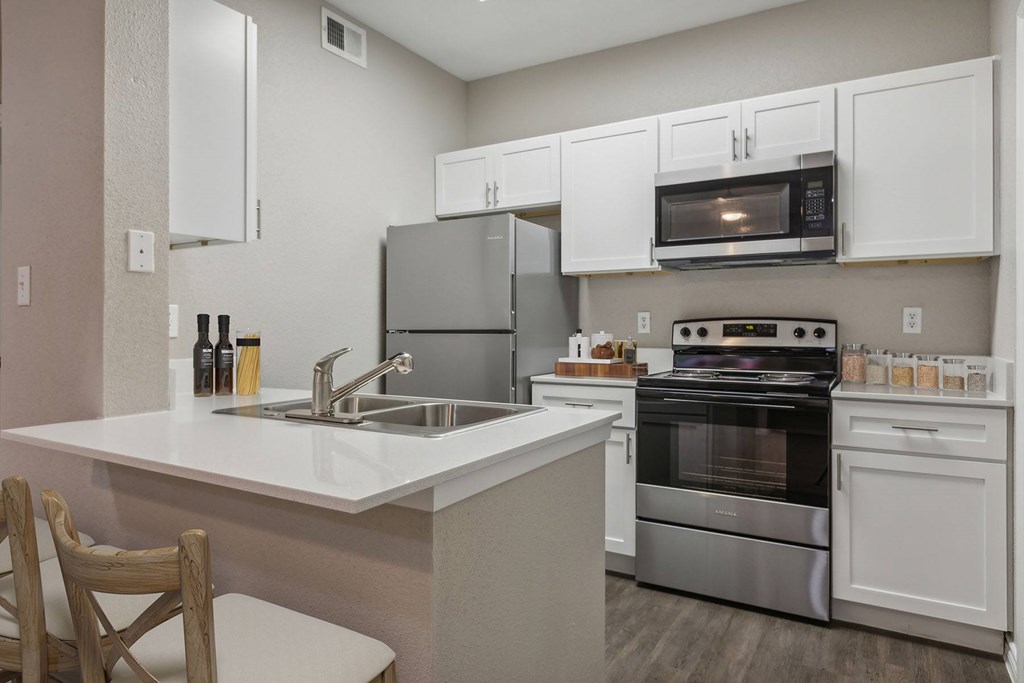 A kitchen with white cabinets and stainless steel appliances.