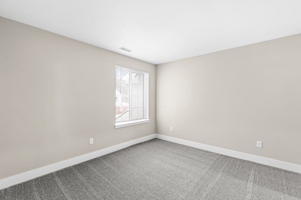 an empty room with white walls and a window