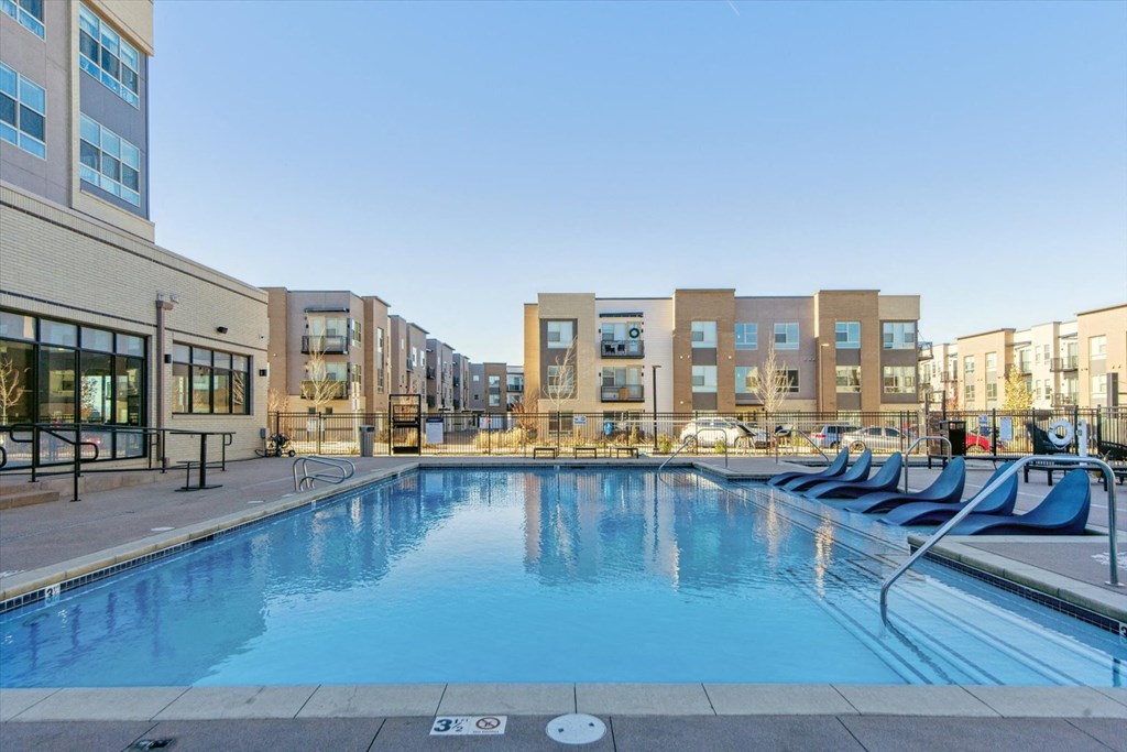 A swimming pool in front of apartment buildings.