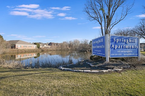 the springhill apartments sign in front of a pond