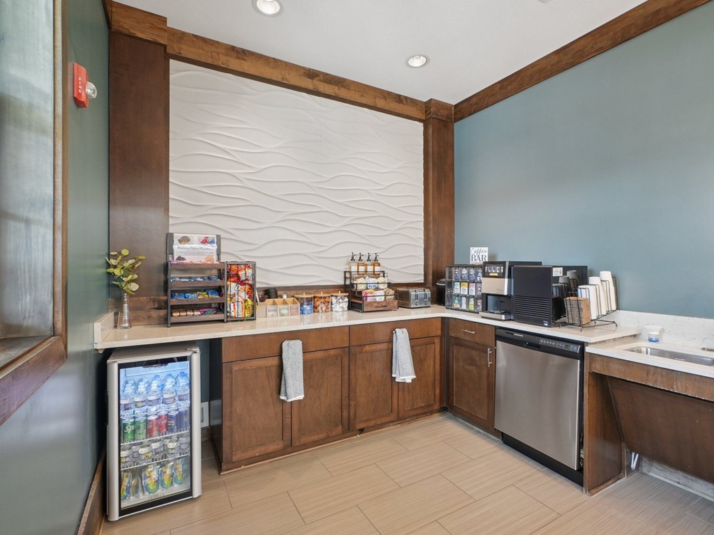 A small cafe with a refrigerator, a sink, and a counter.