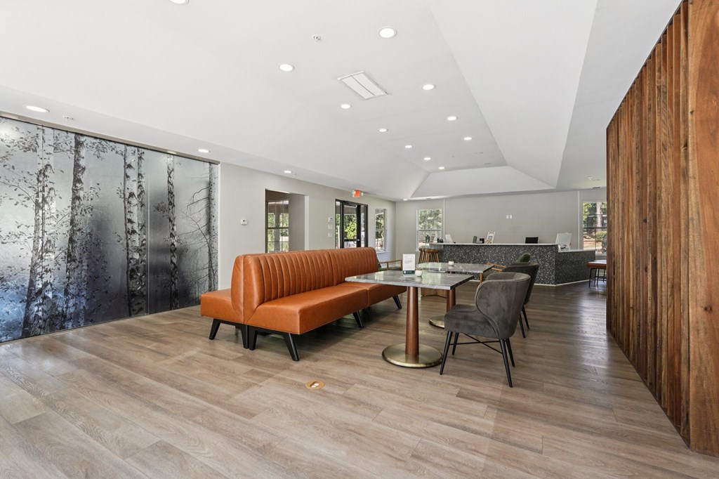 A modern living room with a wooden floor and a glass wall.