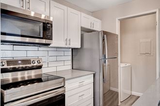 a kitchen with white cabinets and stainless steel appliances