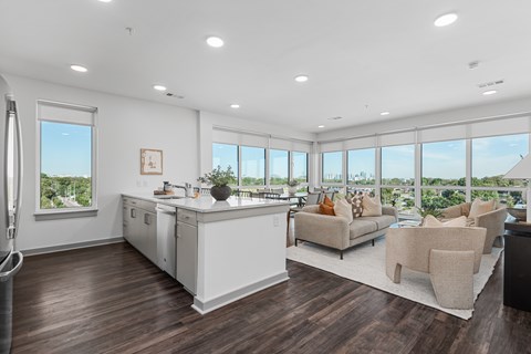 A modern kitchen with white appliances and wooden floors.
