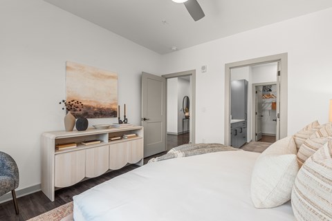 A bedroom with a large bed and a painting on the wall.