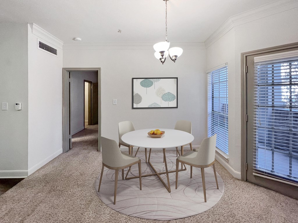 a dining room with a table and chairs and a window