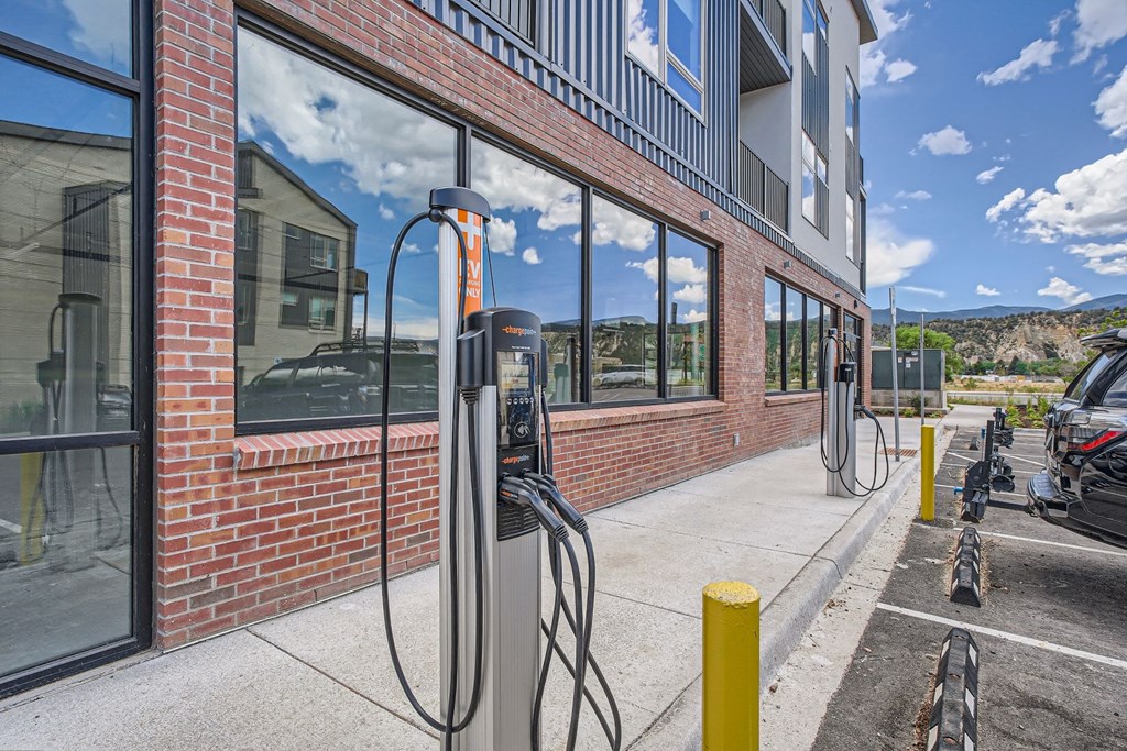 a pair of gas pumps sit outside of a red brick building
