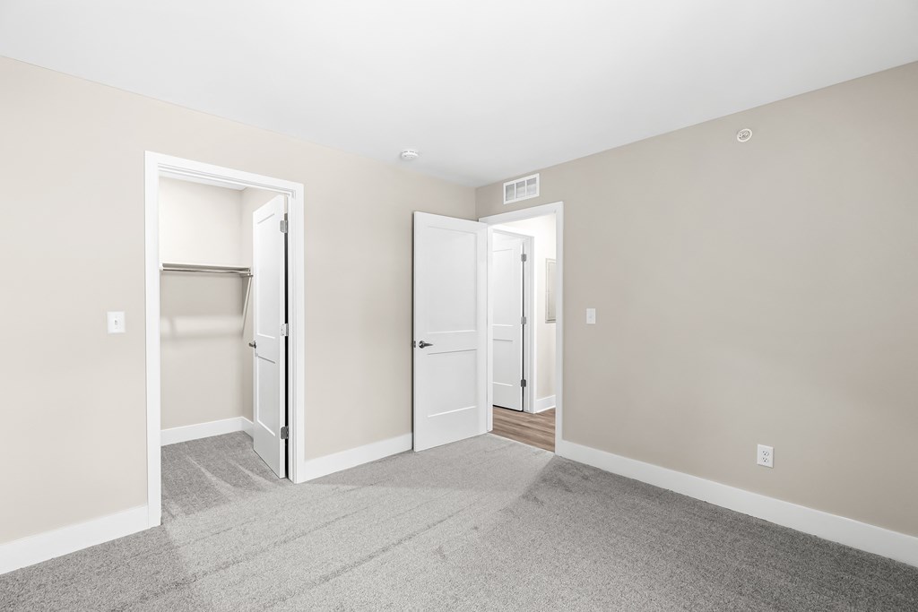 an empty room with three doors and a carpeted floor