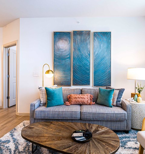 A living room with a grey couch and a wooden coffee table.