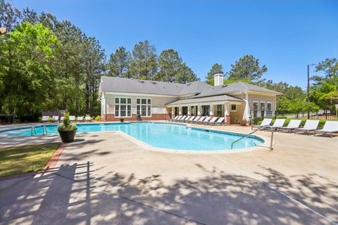 A house with a pool in front of it.