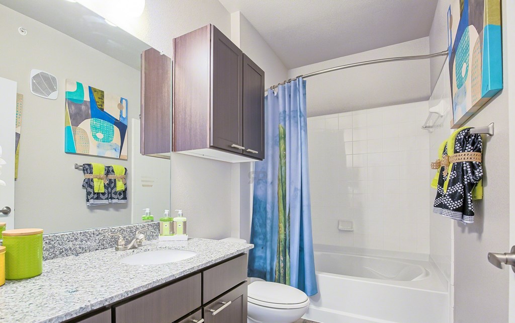 A bathroom with a white sink and a blue shower curtain.