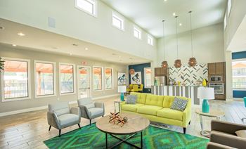 A living room with a yellow couch and a coffee table.