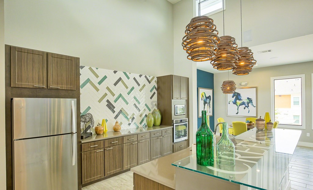A modern kitchen with a glass counter top and wooden cabinets.
