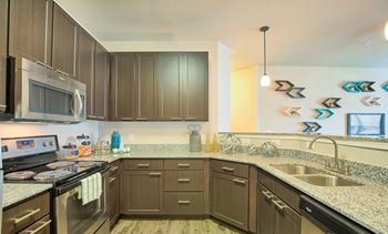 A kitchen with brown cabinets and a stainless steel refrigerator.