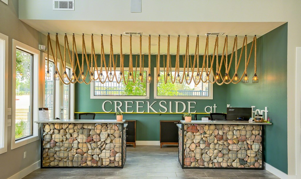 A reception area with a green wall and a sign that says CREEKSIDE at the top.