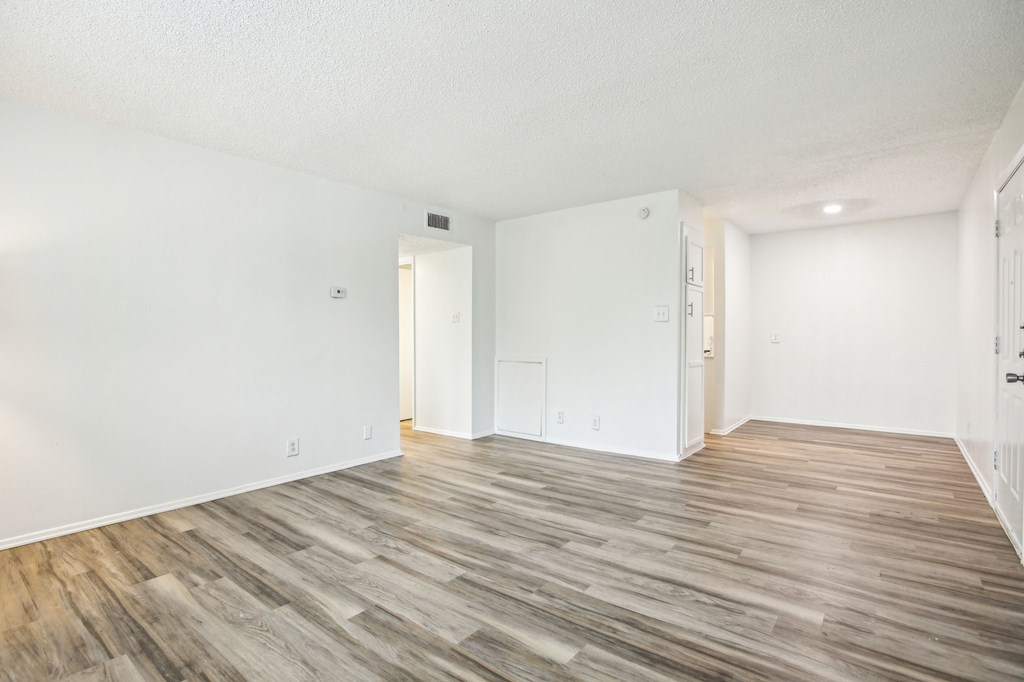 A room with a white wall and a wooden floor.