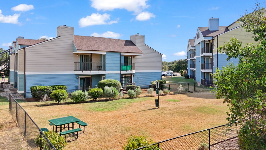 A blue house with a green picnic table in front.