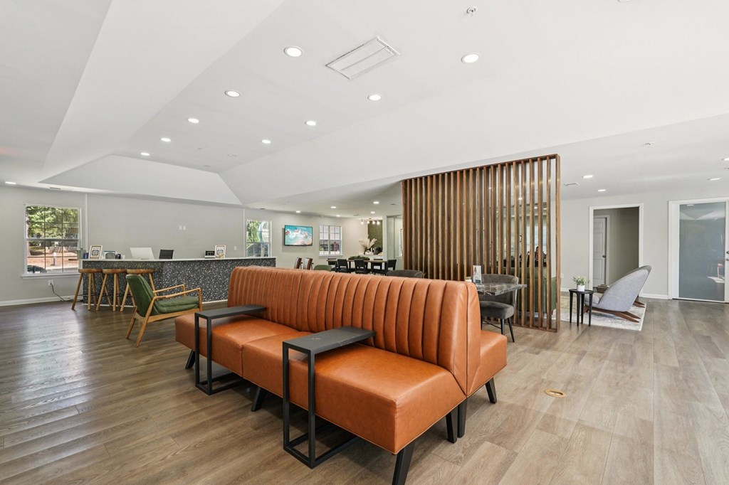 A modern living room with a long orange sofa and wooden flooring.
