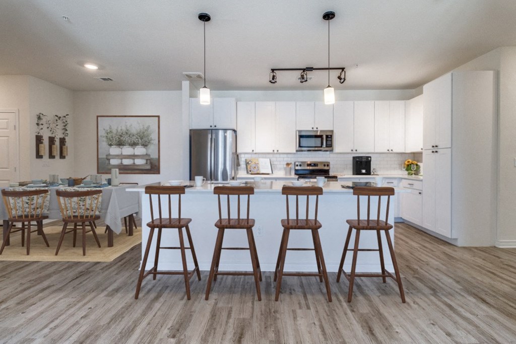 a kitchen and dining area with bar stools in a living room with a kitchen