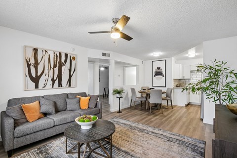 A living room with a grey couch and a brown bowl on the coffee table.