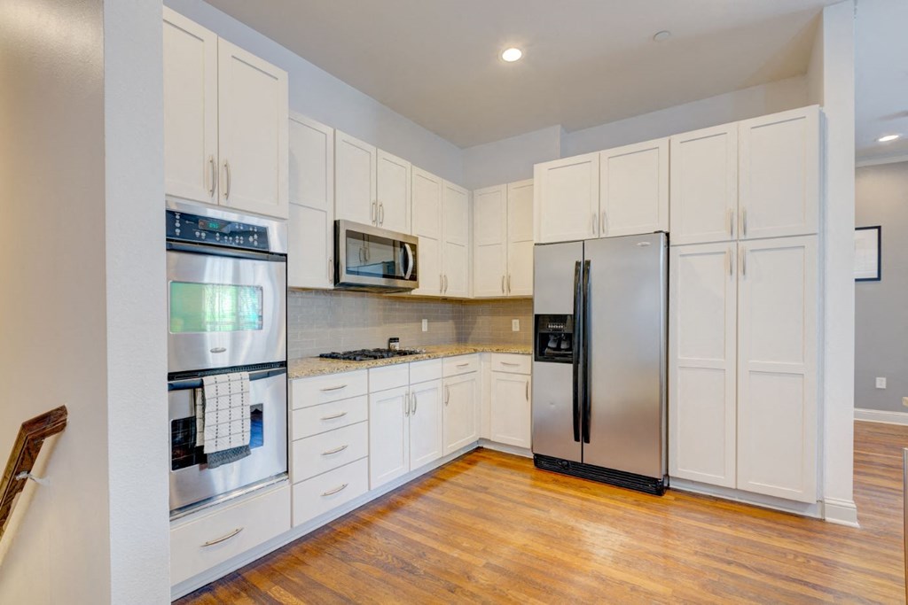 a kitchen with white cabinets and stainless steel appliances