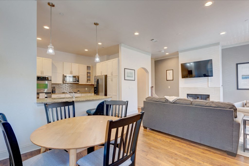 a living room and kitchen with a table and chairs