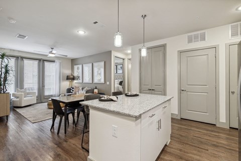 A kitchen with white cabinets and a large island with a countertop.