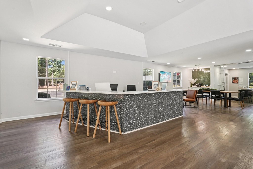 A modern kitchen with a bar area and wooden floors.