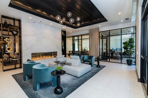 a living room with a white couch and blue chairs and a fireplace