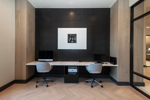 a conference room with two desks and two chairs and a picture on the wall