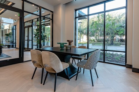 a dining room with a table and chairs and large glass doors