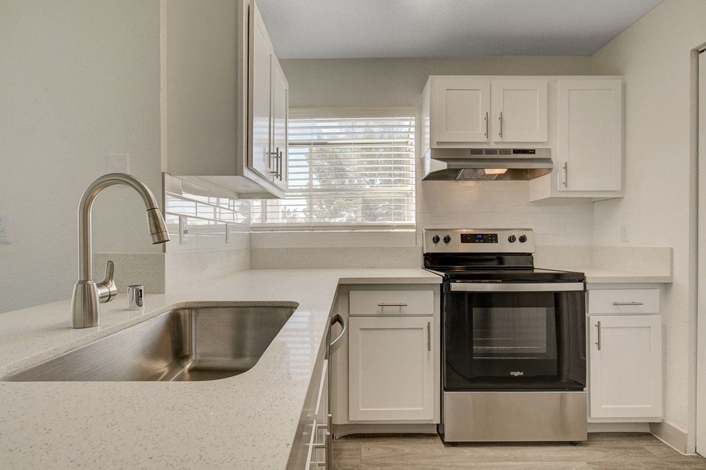 a kitchen with white cabinets and stainless steel appliances
