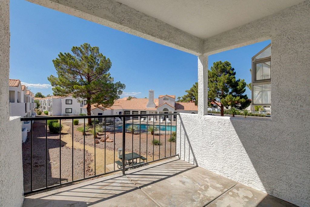 a balcony with a view of a pool and trees
