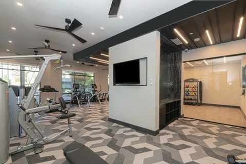 a workout room with a tv and exercise equipment