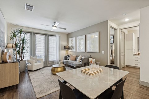 A modern living room with a dining table and chairs.