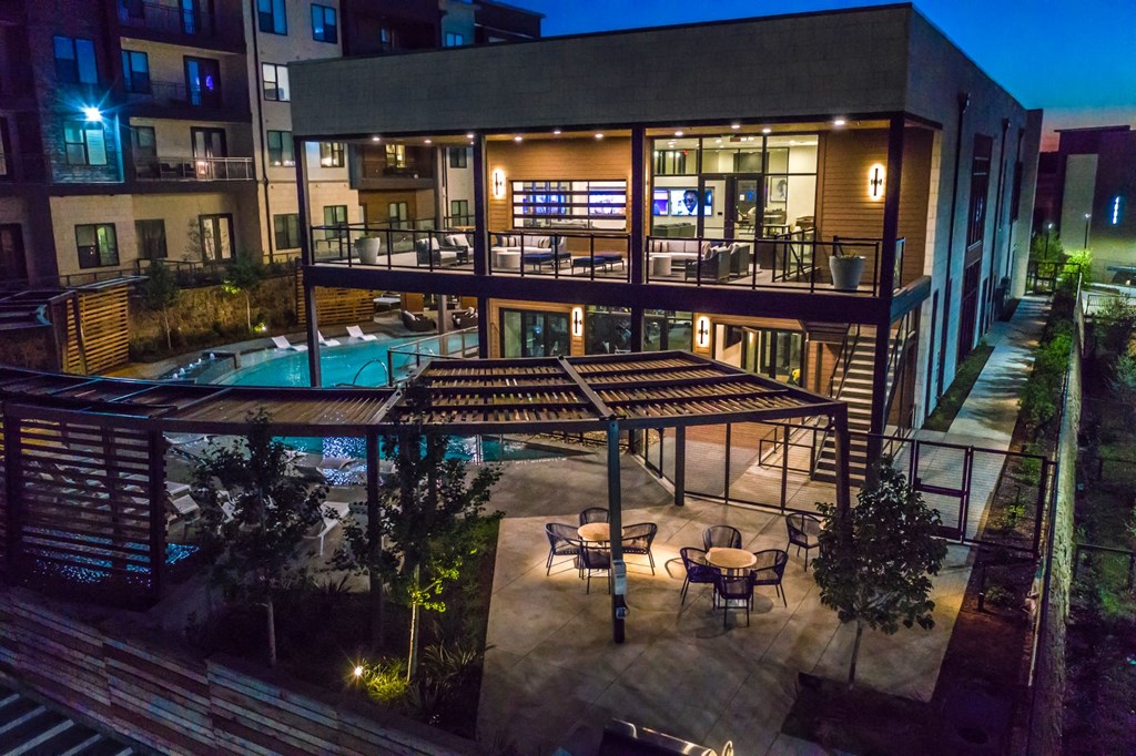 a night view of a building with a pool and patio