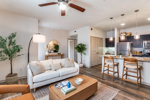 A living room with a white couch and a wooden coffee table.