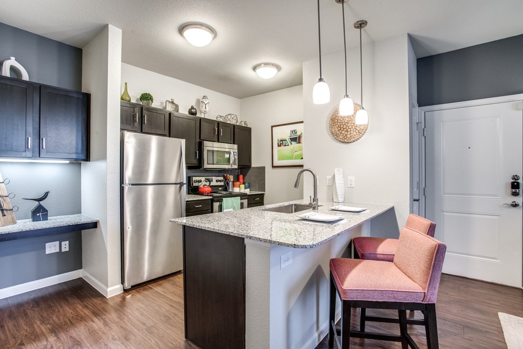 a kitchen with a island and a stainless steel refrigerator