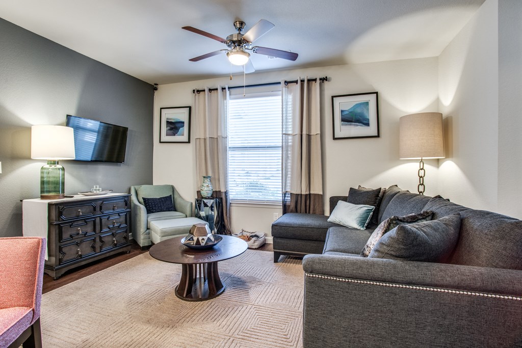 a living room with a couch and chair and a ceiling fan