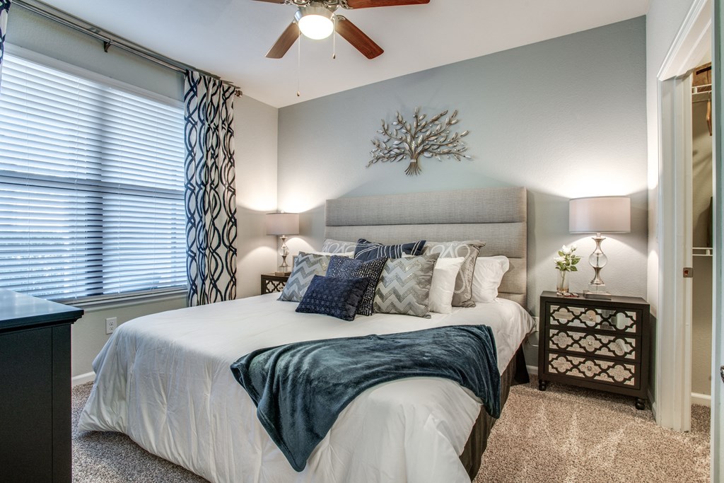 a bedroom with a large bed and a ceiling fan