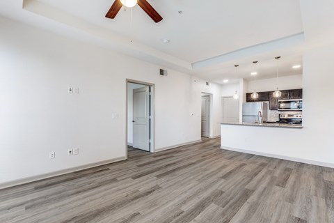 A spacious room with a ceiling fan and wooden flooring.