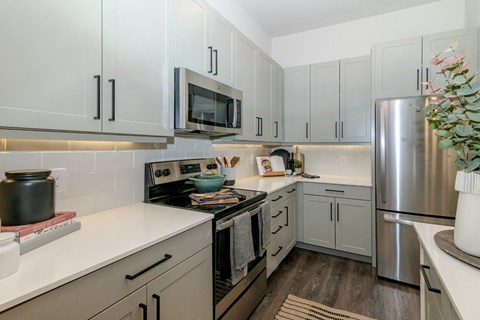 a kitchen with white cabinets and stainless steel appliances