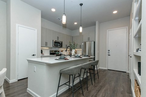 an open kitchen with a large island with stools