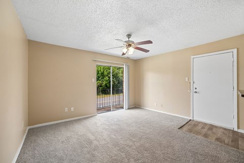 A room with a ceiling fan and carpeted floor.