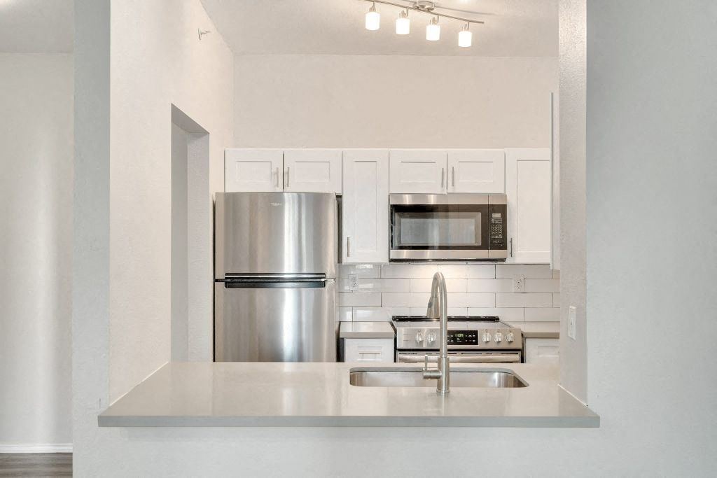 a kitchen with stainless steel appliances and white cabinets
