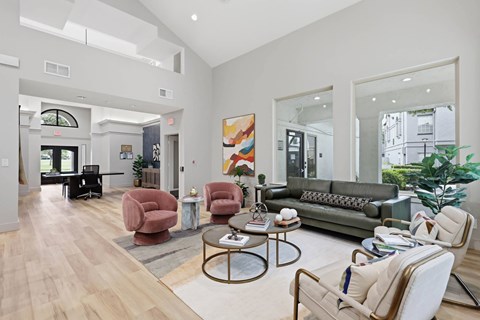 A living room with a grey couch, a coffee table, and a large painting on the wall.