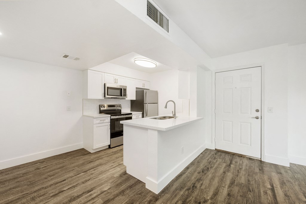 a white kitchen with a white counter top and