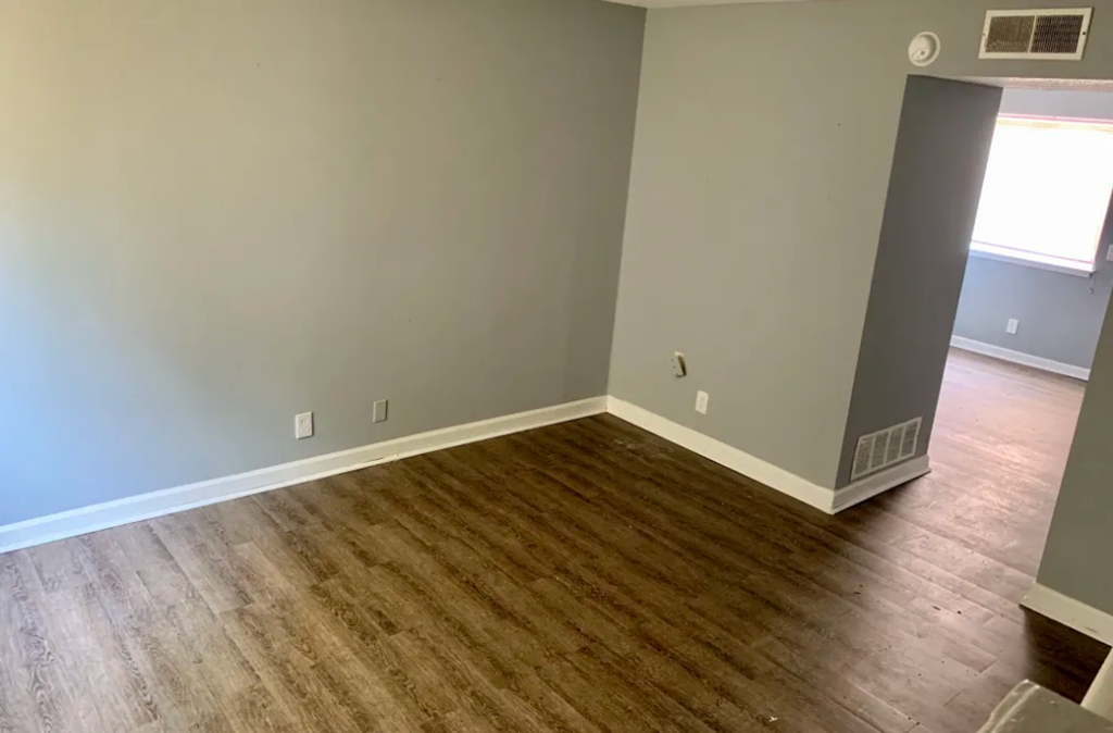a room with a wooden floor and a wall with dots on it